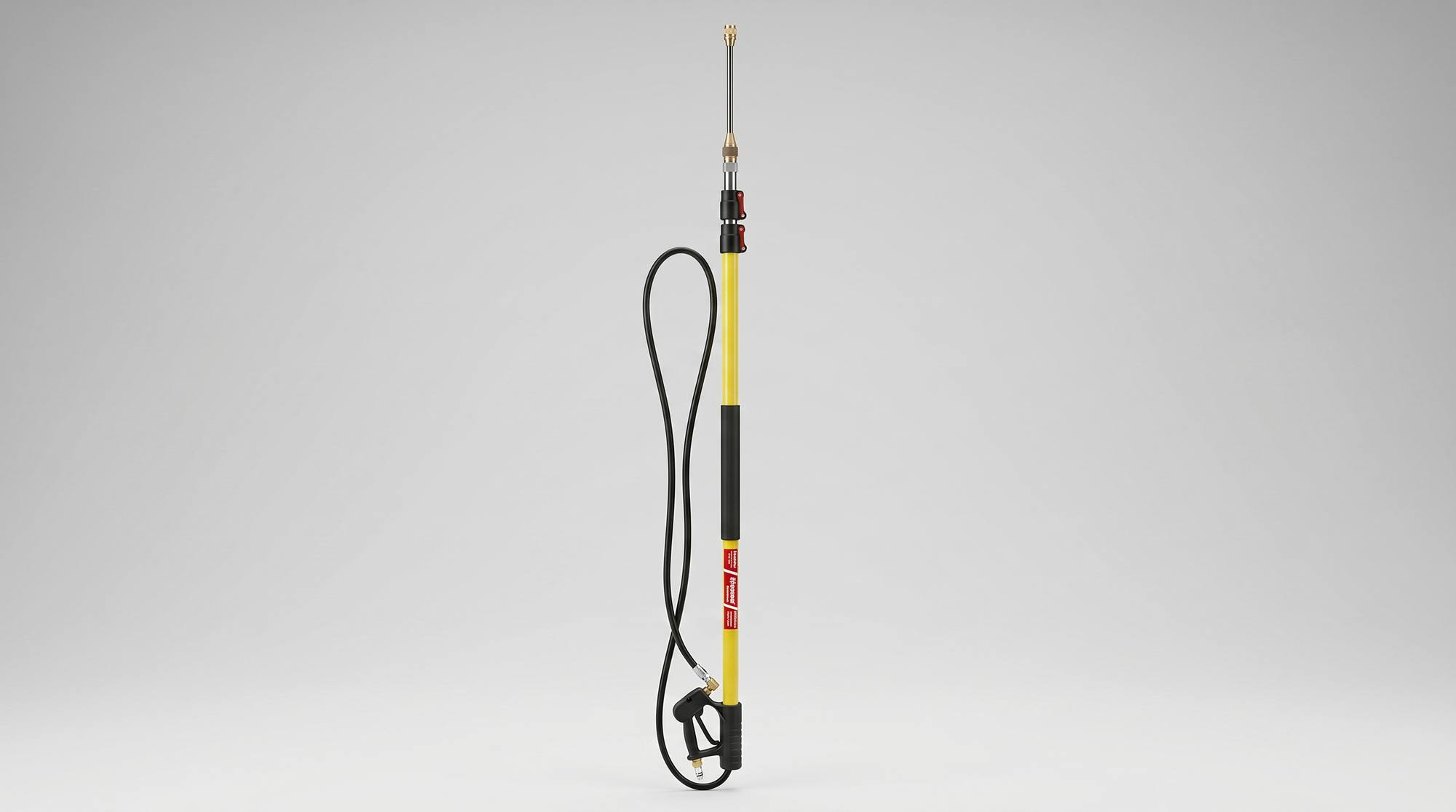 Telescoping pressure-washer wand with yellow extension pole, spray gun, hose, and brass nozzle fitting.