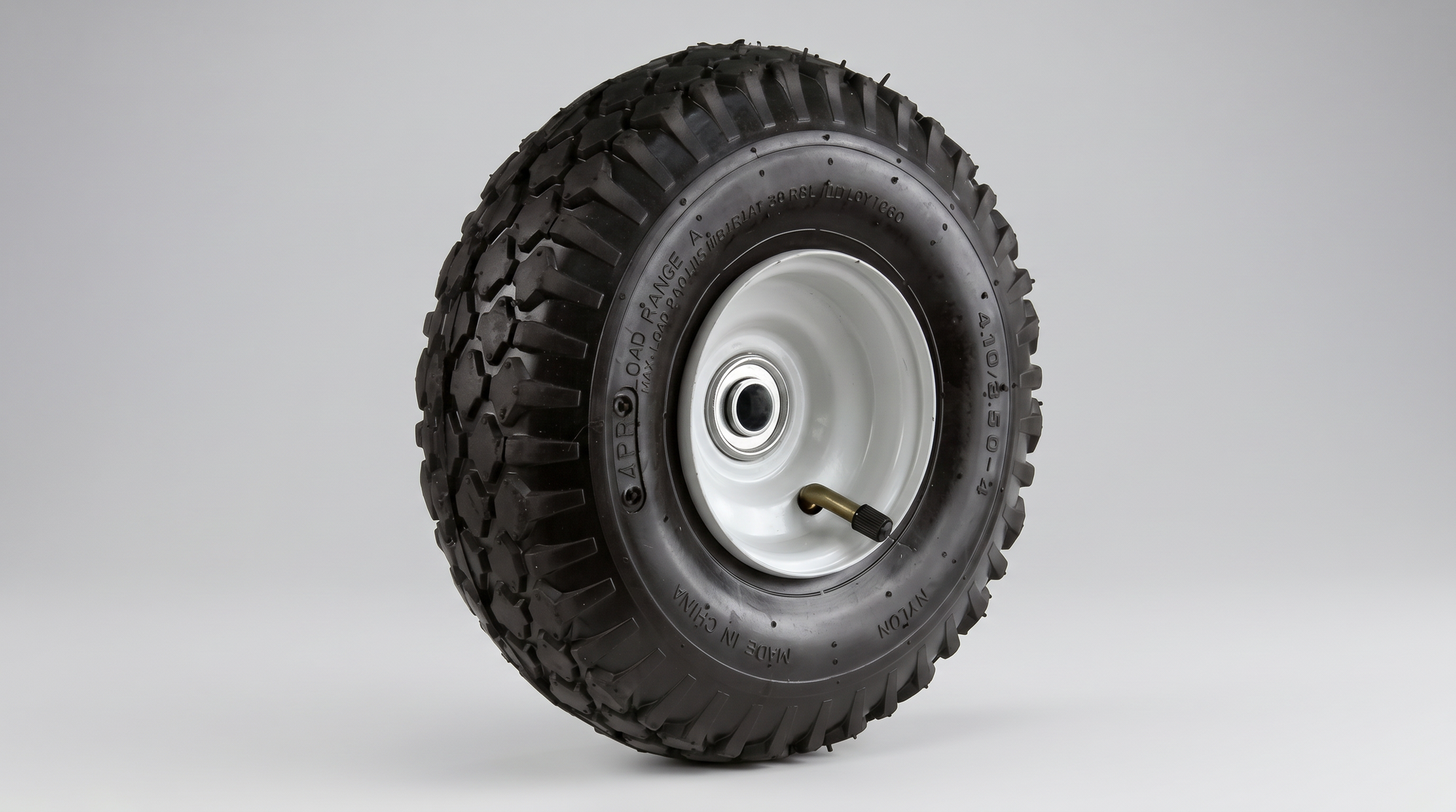 Pneumatic equipment tire with deep tread, white steel rim, bearing hub, and valve stem.