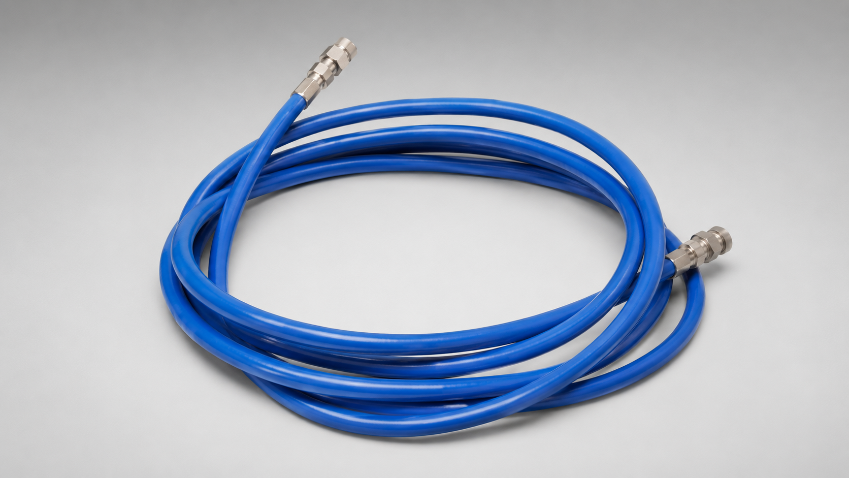 Coiled blue high-pressure water blaster hose with stainless steel quick-connect fittings.